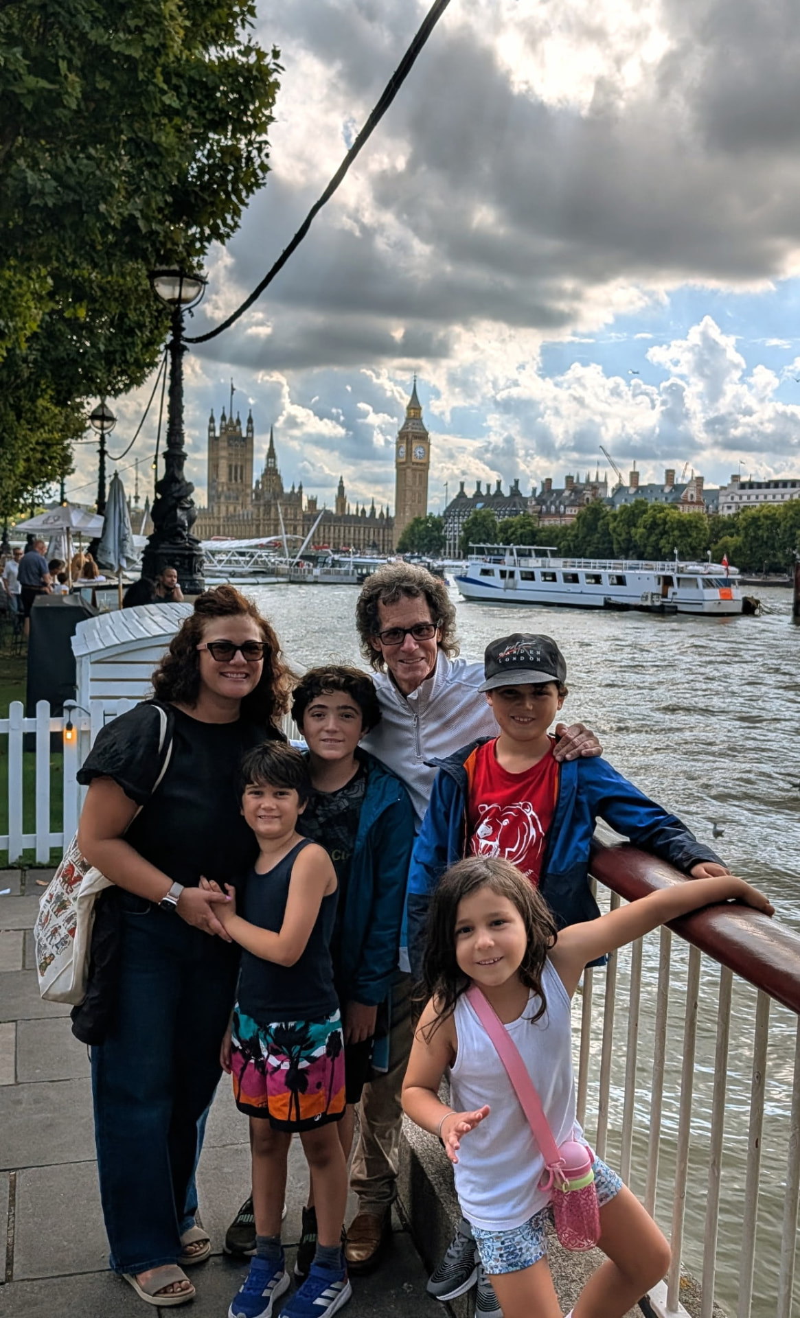Steve L. with his family on the Thames, Big Ben and Parliament behind them
